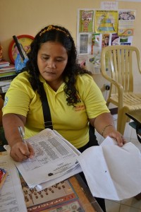 Maribel Audencia of Brgy. Balijuagan, Roxas City helps check the attendance of her co-beneficiaries to the Family Development Session in their barangay as one of the conditions of the Pantawid Pamilyang Pilipino Program.