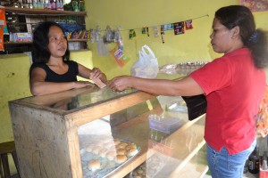 Pantawid Pamilya beneficiary Diolenda Garsola attends to a customer in their bakeshop.