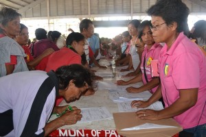 Parent Leader Elma Alavaro (right) of Barangay Bato, Panay, Capiz assists in the validation of Pantawid Pamilyang Pilipino Program beneficiaries during the over-the-counter payout.