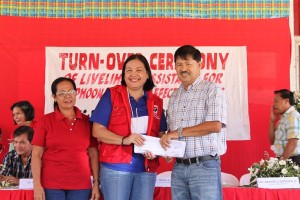 Mayor Arnold Betita receives the livelihood assistance for his constituents in Carles, Iloilo from DSWD regional director Ma. Evelyn B. Macapobre. Witnessing are other mayors and local officials.