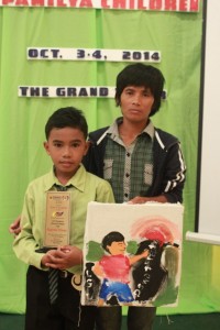 Mark Lovel Bedona, 2014 regional child exemplar in Western Visayas, holds his painting and plaque. With him is his mom Merlyn. The family from Bugasong, Antique is a beneficiary of DSWD Pantawid Pamilyang Pilipino Program.