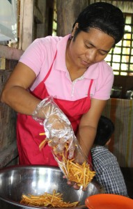 Rosemarie dela Rama packs the banana sticks her husband had just cooked.