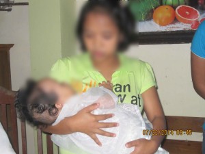 A resident of the Regional Center for Women is shown here  during the Christening of her baby