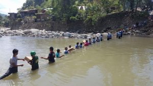 Police, volunteers, social workers and ordinary citizens imbibe the Bayanihan spirit as they cross a river to deliver relief resources to far-flung communities affected by Typhoon 'Lawin.'